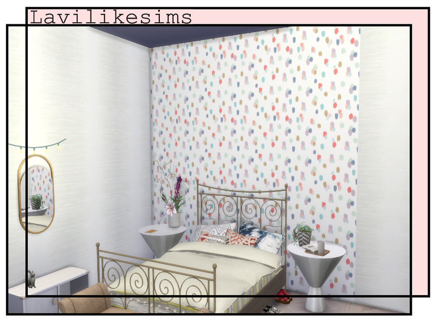 A bedroom with a metal bed, rounded side tables and white walls, one wall behind the bed has white wallpaper with small randomly sized colourful clusters. 