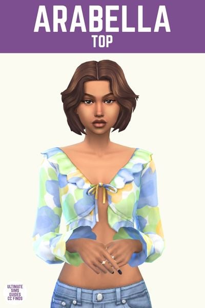 This image has a purple bar at the top with white text that reads "Arabella Top" and below is a sim wearing a ruffle hem blouse with a water colour design in blue and green 