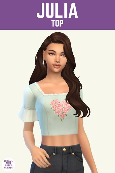 This image has a purple bar at the top that has white text says "Julia Top" and below is a sim with dark brown hair wearing black jeans and a cropped top with a roses in the shape of a heart design 