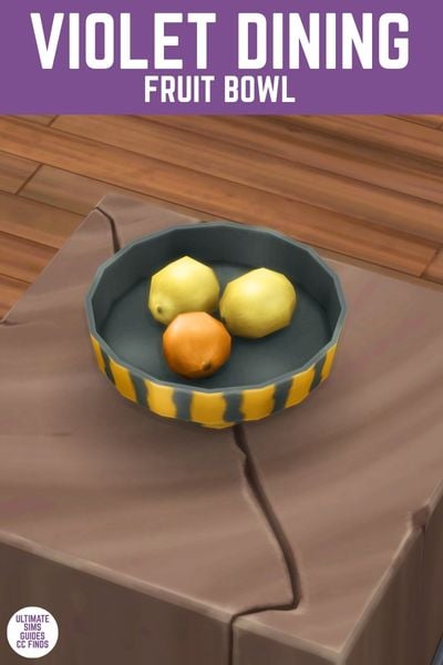This image has a purple bar at the top with white text that says "Violet Dining Fruit Bowl" and below is a wood slab with a bowl with oranges and lemons in it 
